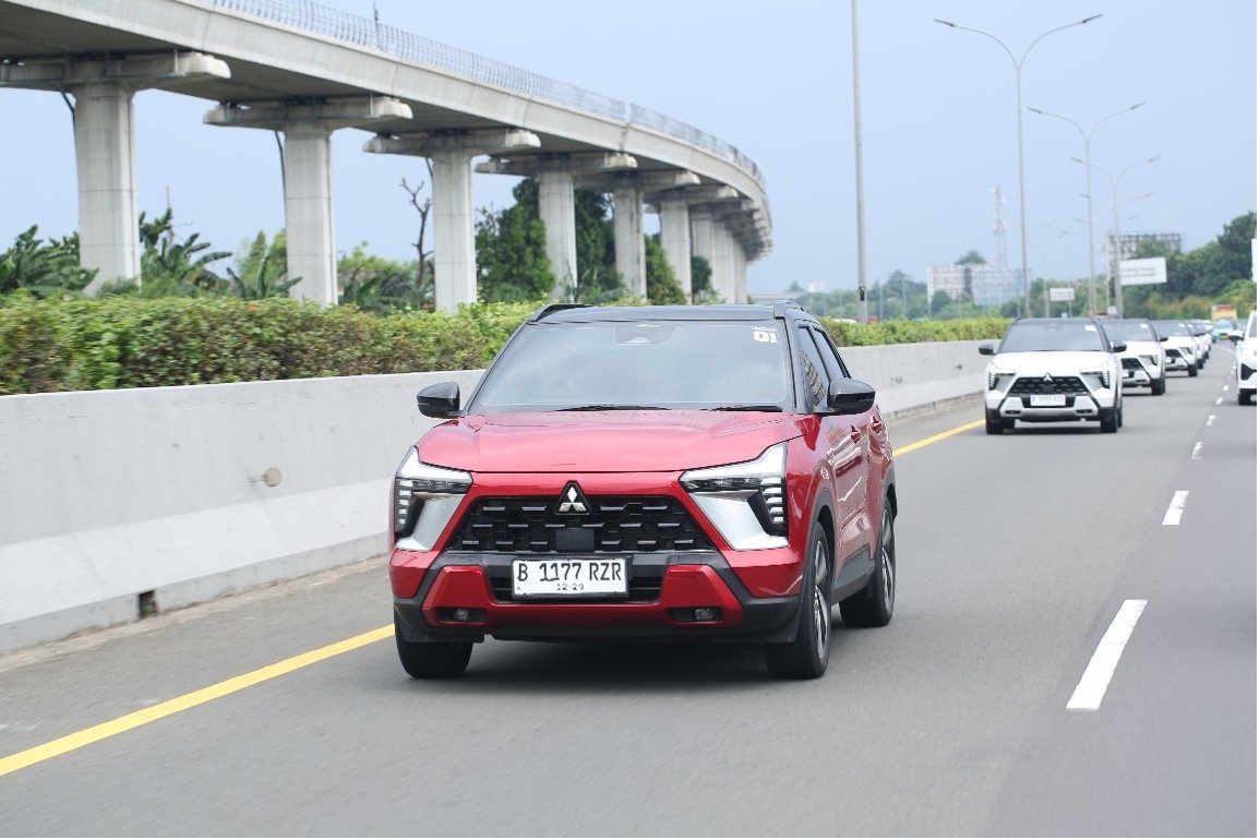 A red car on a road Description automatically generated